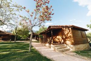 a small building with a tree in the grass at Vall d'Àger Resort & Camping in Ager
