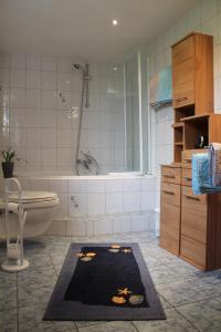 ein Badezimmer mit einer Badewanne, einem WC und einem Teppich in der Unterkunft Ferienhaus Wingarda in Weingarten
