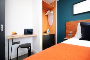 1 dormitorio con 1 cama y escritorio con ordenador portátil en Boutique one bedroom apartment in Cardiff, en Cardiff