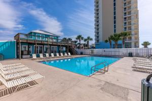 巴拿馬市海灘的住宿－Gulf Highlands-Flip Flop Inn，一座带躺椅的游泳池和一座建筑