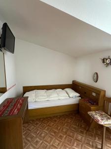 a small bedroom with a bed and a tv at Appartamenti Detomaso in Masarei