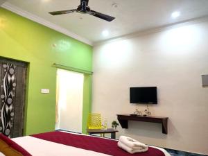 a bedroom with a bed and a flat screen tv at Naadi Hotel New Busstand Thanjavur in Thanjāvūr