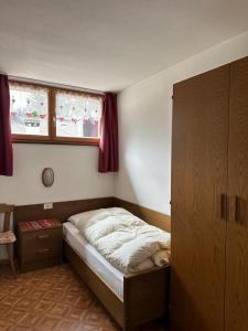 a small bedroom with a bed and two windows at Appartamenti Detomaso in Masarei