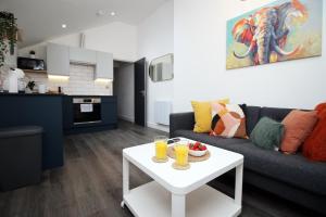 a living room with a couch and a table with drinks on it at Boutique one bedroom apartment in Cardiff in Cardiff