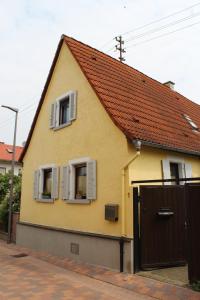 a yellow house with a brown roof and a gate at Ferienhaus Wingarda in Weingarten