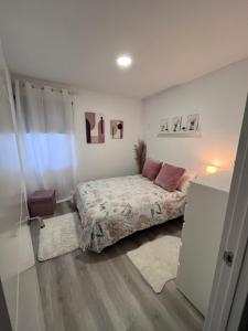 ein kleines Schlafzimmer mit einem Bett und einem Fenster in der Unterkunft Apartamento cerca aeropuerto in Pontevedra
