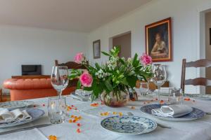 una mesa de comedor con flores rosas en un jarrón en Chez Maryse et Guy - Bel Appt pour 4 avec jardin, en La Ville-aux-Clercs