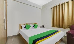 a bedroom with a bed and a chair in a room at Treebo SLN Heritage in Bengaluru