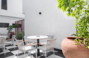 萊基的住宿－Ulo Lagos，庭院配有白色的椅子和白色的桌子。