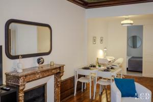ein Wohnzimmer mit einem Kamin, einem Tisch und Stühlen in der Unterkunft Le Berbisey Dijon Centre in Dijon