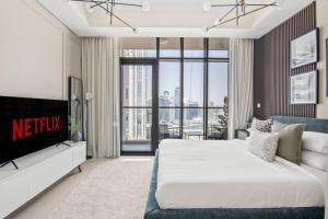 - une chambre avec un lit king-size et une télévision dans l'établissement GuestReady - Contemporary studio in Business Bay, à Dubaï