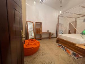 1 dormitorio con 1 cama y 1 órbita naranja en Amba Kola Udawalawa, en Udawalawe