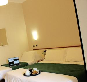 um quarto de hotel com uma cama e um computador portátil numa mesa em Blue Loft Hotel em Cesenatico