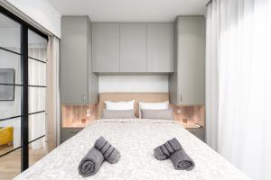 sypialnia z dużym łóżkiem i 2 szarymi kapciami w obiekcie Alkis Luxury By Greece Apartments w Atenach