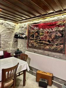 a dining room with a table and a painting on the wall at SEMRA HANIM KONAĞI in Safranbolu