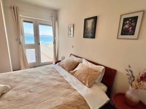 um quarto com uma cama e vista para o oceano em Beach Apartment w Sea Views, 3x Bedrooms w En-Suites em Sibenik