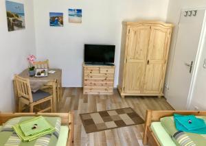 ein Wohnzimmer mit 2 Betten und einem TV in der Unterkunft Abelia Ferienwohnung GröF in Helmstedt