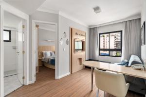 a white room with a desk and a bed at Suítes INNSIDE Pinheiros Hotel in Sao Paulo