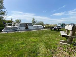 una barca parcheggiata in un campo vicino a un tavolo da picnic di Boat Jan van Gent-niet om mee te varen a Jutrijp