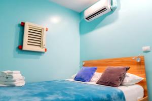 a blue room with a bed and a window at Bed & Bike Curacao in Willemstad