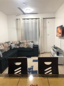ein Wohnzimmer mit einem Sofa und 2 Stühlen in der Unterkunft Leisure apartment in Mombasa