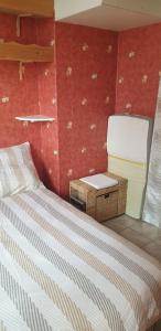 a small bedroom with a bed and a chair at Appartement front de mer vue mer 3 personnes + 1 bebe in Hermanville-sur-Mer