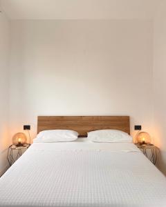 a bedroom with a large white bed with two lamps at Nacàri Home in Giardini Naxos