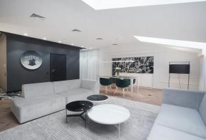 een woonkamer met een witte bank en een tafel bij Hotel Park 17 in Częstochowa