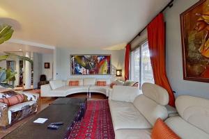 sala de estar con sofás blancos y alfombra roja en Appartement grand luxe 180m2, en Neuilly-sur-Seine