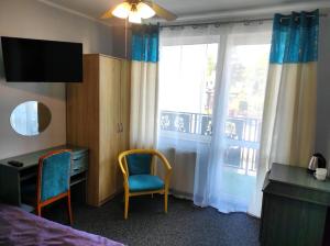 a room with a bed and a desk and a window at Pod Różą B&B in Ustka