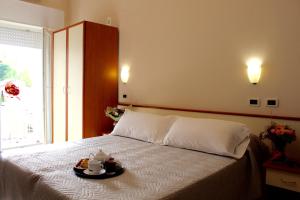 um quarto com uma cama com uma bandeja de comida em Blue Loft Hotel em Cesenatico