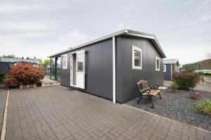 een klein grijs huis met een bank in een tuin bij Haus Ferdi in Koblenz