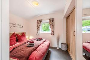 ein Schlafzimmer mit einem roten Bett und einem Fenster in der Unterkunft Haus Ferdi in Koblenz