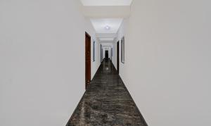 an empty corridor of a white room with a long hallway at Treebo Trend SLN Heritage in Bangalore