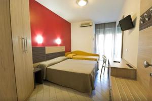 a hotel room with a bed and a red wall at Hotel Sydney in San Benedetto del Tronto +40 photos