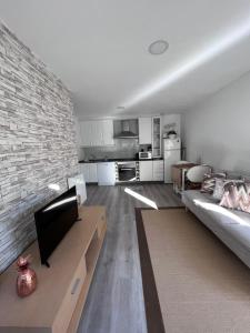 uma sala de estar com um sofá e uma parede de tijolos em Apartamento cerca aeropuerto em Pontevedra