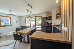 a kitchen and living room with a table and chairs at Spacieux appartement au pied des pistes in La Féclaz