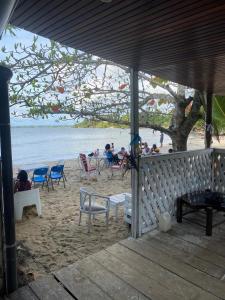 克里比的住宿－Kribi Trip Experience，一群人坐在沙滩上的椅子上