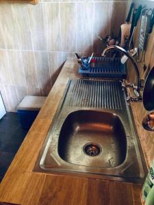 - un évier en métal dans la cuisine avec un comptoir en bois dans l'établissement Kribi Trip Experience, à Kribi