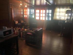 克里比的住宿－Kribi Trip Experience，客厅配有椅子和桌子,设有窗户