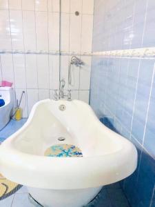 um lavatório branco numa casa de banho com azulejos azuis em Kribi Trip Experience em Kribi