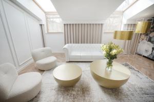 uma sala de estar com mobiliário branco e uma mesa e cadeiras em Hotel Park 17 em Częstochowa