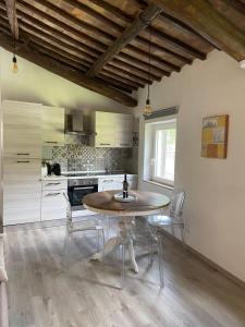 a kitchen with a table and chairs in a room at Casa Biscarello - Borgo e Lago in Grotte di Castro