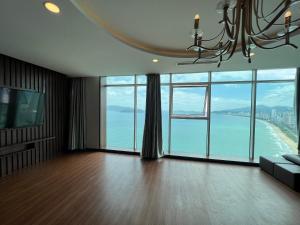 uma sala de estar com um lustre e vista para o oceano em BELIEVER APARTMENT em Nha Trang