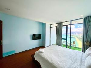 um quarto com uma cama grande e uma janela grande em BELIEVER APARTMENT em Nha Trang