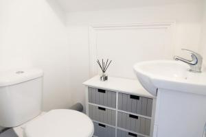 a white bathroom with a toilet and a sink at 5 Bed Luxury London Home in London