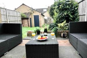 a table with a bowl of fruit and a bottle of wine at 5 Bed Luxury London Home in London
