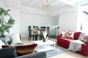 a living room with a red couch and a table at 5 Bed Luxury London Home in London +14 photos