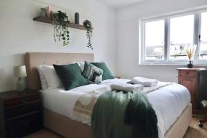 a bedroom with a large bed with green pillows at 5 Bed Luxury London Home in London
