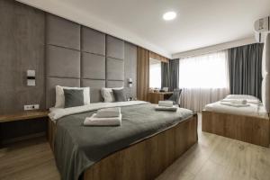 a bedroom with a large bed with towels on it at Kompleks Milosevic in Bijeljina